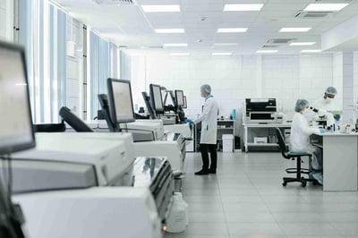 Wide view of a modern analytical laboratory with chromatography and MS instruments and a staff member in PPE, illustrating CMC method development, characterization, and release or stability testing in Cranbury, New Jersey.